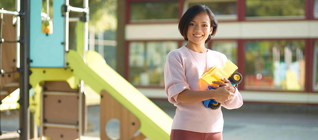  Pedagogisch Medewerker poseert vrolijk op schoolplein